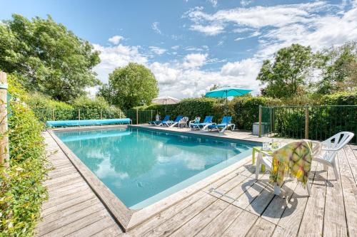 - une piscine avec des chaises et une table à côté d'une terrasse en bois dans l'établissement Chambres d'hôtes les Hautes Papinières, à Saint-Prouant