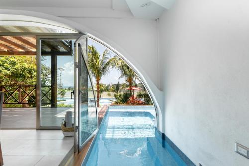an indoor swimming pool in a house with an archway at Villas Amanecer by Andiani Travel in Isla Mujeres