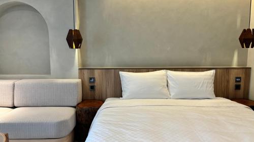 a bedroom with two beds with white sheets at Hotel Initial-Tainan in Tainan