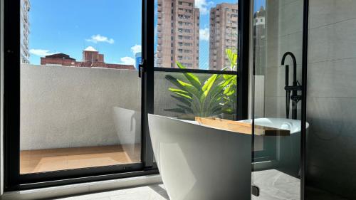 a bathroom with a shower and a sink and a window at Hotel Initial-Tainan in Tainan
