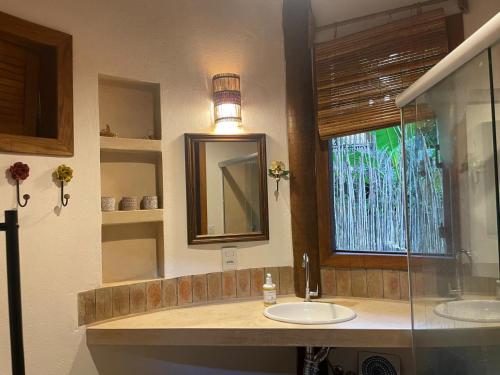 a bathroom with two sinks and a mirror and a window at Vila Pitanga - Arandis in Marau