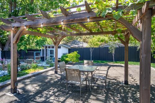 a patio with a table and chairs under a wooden pergola at Chic RV Retreat, Stunning Yard in Roseburg in Roseburg