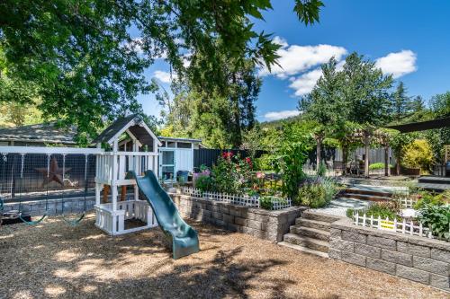 a playground with a slide in a garden at Chic RV Retreat, Stunning Yard in Roseburg in Roseburg