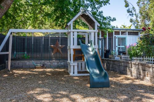 a playground with a slide and a play house at Chic RV Retreat, Stunning Yard in Roseburg in Roseburg