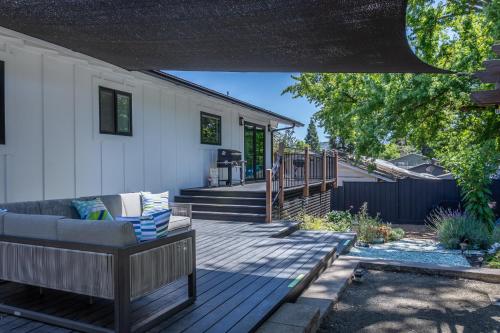 a patio with a couch on a wooden deck at Chic RV Retreat, Stunning Yard in Roseburg in Roseburg