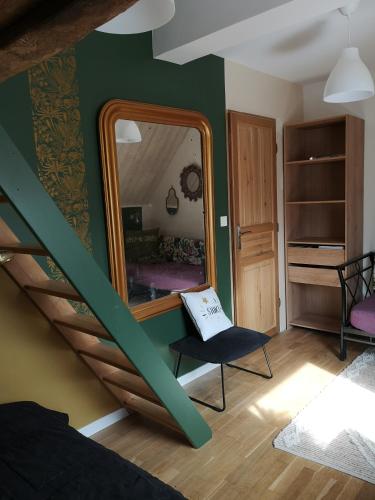 Cette chambre comprend un miroir et une chaise. dans l'établissement L'étable buissonnière, à Saint-Pierre-Langers