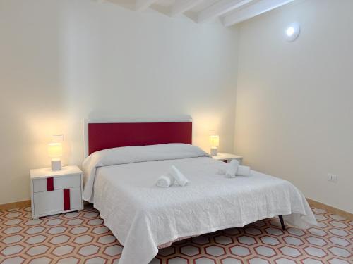 a bedroom with a white bed with two lamps at B&B Aquas in Sardara