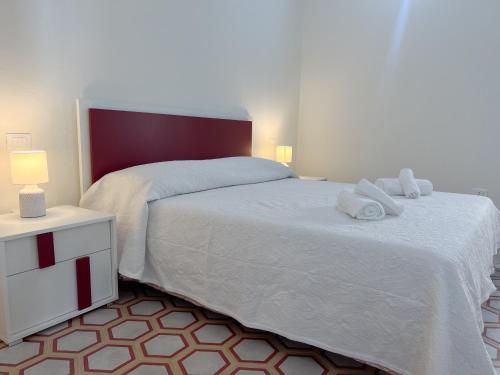 a bedroom with a large white bed with towels on it at B&B Aquas in Sardara