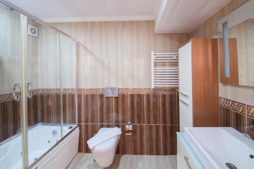 a bathroom with a toilet and a tub and a sink at Grand Zentrum Hotel in Istanbul