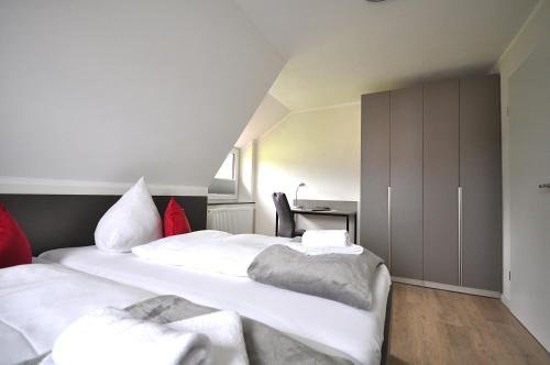 a bedroom with two white beds and a desk at Geschmackvolle moderne Apartment-Wohnungen in Hünfeld