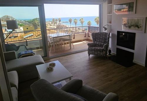 a living room with a couch and chairs and a balcony at Apartamento Bonavista in Vilassar de Mar