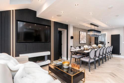 a living room with a table and a dining room at Riverside Villas in Manchester