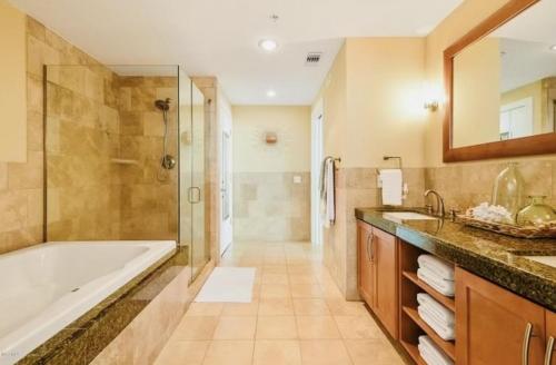 a bathroom with a tub and a shower and a sink at Ocean Front Paradise in Biloxi