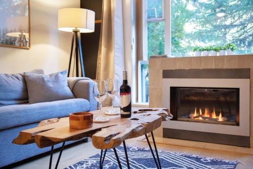 a living room with a couch and a fireplace at Glacier Lodge Premiere Suite in Whistler