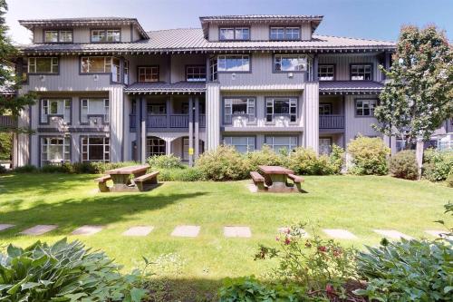a large building with two benches in the yard at Glacier Lodge Premiere Suite in Whistler