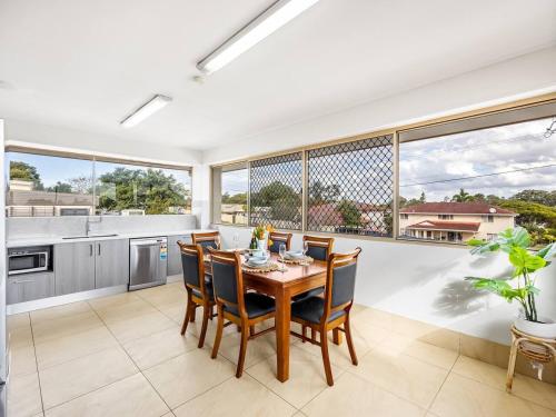 a kitchen and dining room with a table and chairs at Spacious Central located Family House at Sunnybank in Brisbane