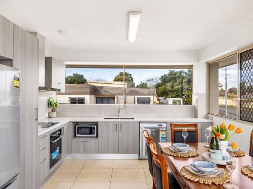 a kitchen with a table and chairs and a large window at Spacious Central located Family House at Sunnybank in Brisbane
