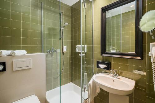 a bathroom with a sink and a glass shower at Hotel NockResort in Bad Kleinkirchheim