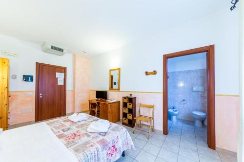 a bedroom with a bed and a bathroom with a toilet at Hotel Badde Rosa in Bolotana