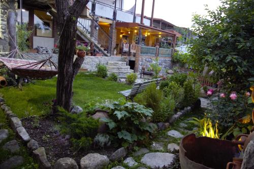 a garden with a hammock in front of a building at Kadori Hills in Tʼelavi
