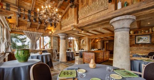 a dining room with tables and a chandelier at La Bouitte - Hôtel Relais & Châteaux in Saint-Martin-de-Belleville