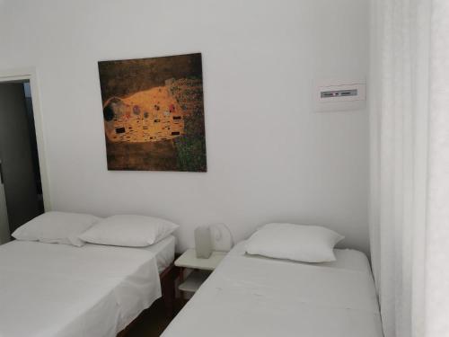 a room with two beds and a painting on the wall at Thalassa3 in Andros
