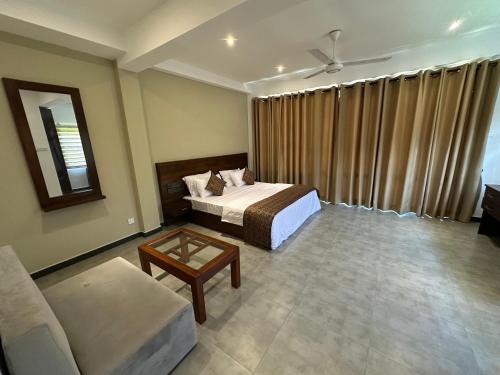 a hotel room with a bed and a couch at Cocos Polhena in Matara