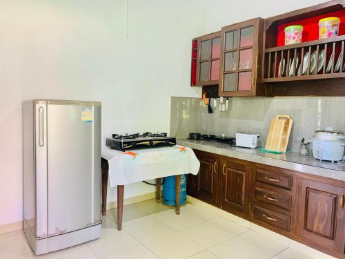 eine Küche mit einem Kühlschrank und einem Tisch darin in der Unterkunft Modern Apartment near Galle Fort, Galle in Galle