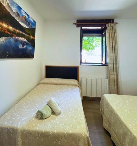 a bedroom with two beds and a window at Apartamentos Melgarden - La casa de Elechas in Elechas