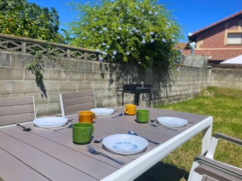 a table with plates and utensils on top of it at Apartamentos Melgarden - La casa de Elechas in Elechas