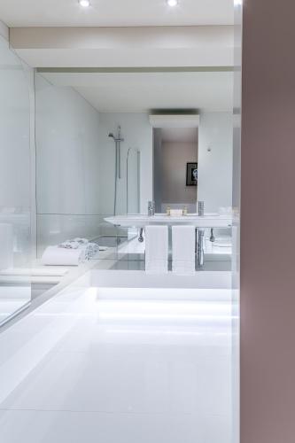 a white room with a table and a mirror at 4615 Hotel in Felgueiras