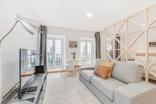a living room with a couch and a television at By the River - Alcantara Apartments in Lisbon