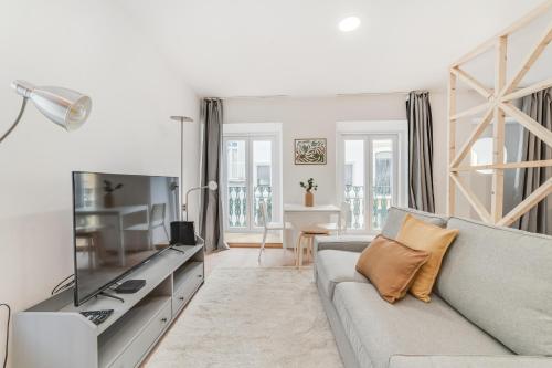 a living room with a couch and a television at By the River - Alcantara Apartments in Lisbon