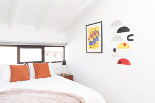 a bedroom with a bed with orange pillows and a window at Solara Art Hotel by Amak in Cusco