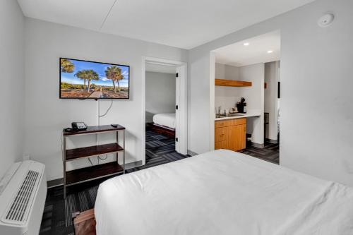 a bedroom with a white bed and a bathroom at Holiday Shores Myrtle Beach in Myrtle Beach
