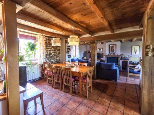 a dining room and living room with a table and chairs at Casa Rural Tozolosolobos in Otero de Bodas