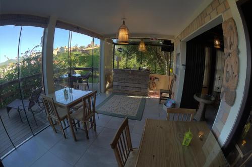 a room with a balcony with tables and chairs at Pousada da Encosta in Garopaba