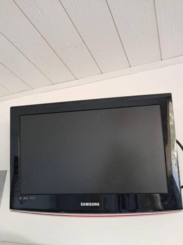 un téléviseur Samsung posé sur un mur dans l'établissement Studio Arc En Ciel 1 - 25 allée des Pinons - 9-1, à Saint-Jean-de-Monts