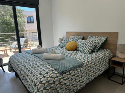 une chambre avec un lit et un balcon dans l'établissement Appartement au calme à 1km du port de Bonifacio, à Bonifacio