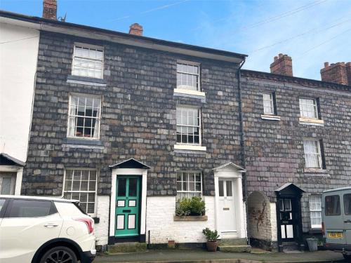 a brick house with a white car parked in front of it at Georgian Terrace Town House in Mid Wales in Newtown