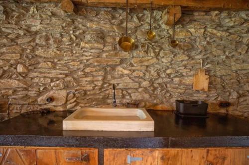 a stone bathroom with a sink and a stone wall at Borda Jarca, casa rústica en plena naturaleza - HUT 8142 in Prats