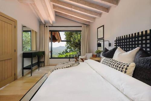 バジェ・デ・ブラボにあるCasa Sol In Avándaro with jacuzzi and lake viewの大きな白いベッドと窓のある寝室