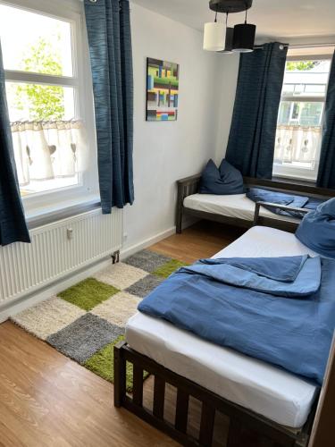 a bedroom with two beds and two windows at Ferienwohnung am Crisela in Ebersbach Sachsen