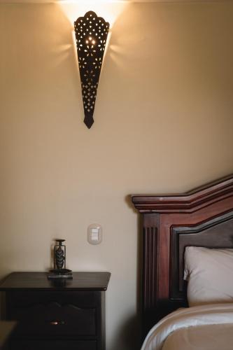 a bedroom with a bed and a table with a lamp at Hotel El Reith Lake in Granada