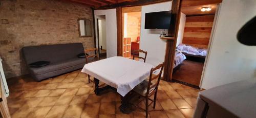 a living room with a table and a couch at Ferme Pédagogique " L'Bout d'Chemin" in Genevreuille