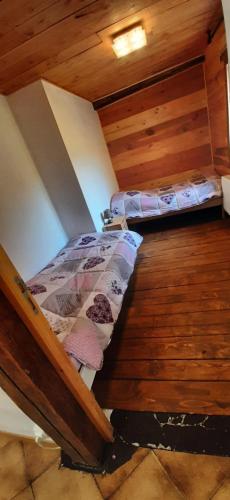 two beds in a room with wooden walls at Ferme Pédagogique " L'Bout d'Chemin" in Genevreuille