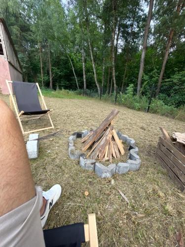 a person sitting in front of a fire pit at Rudkowa Sielanka in Rudka