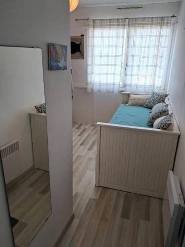 une petite chambre avec un lit et une fenêtre dans l'établissement Studio Arc En Ciel 2 - 27 allée des pinons - 6-1, à Saint-Jean-de-Monts