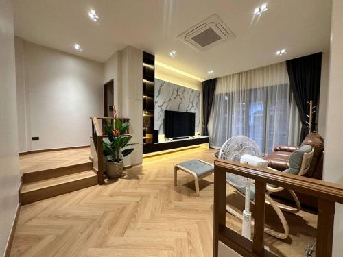 a living room with a couch and a television at Naka Central Happy Home in Phuket city in Ban Rangeng