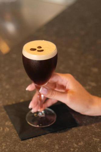a hand holding a wine glass with a drink at Hotel Medinblu in Reggio Calabria
